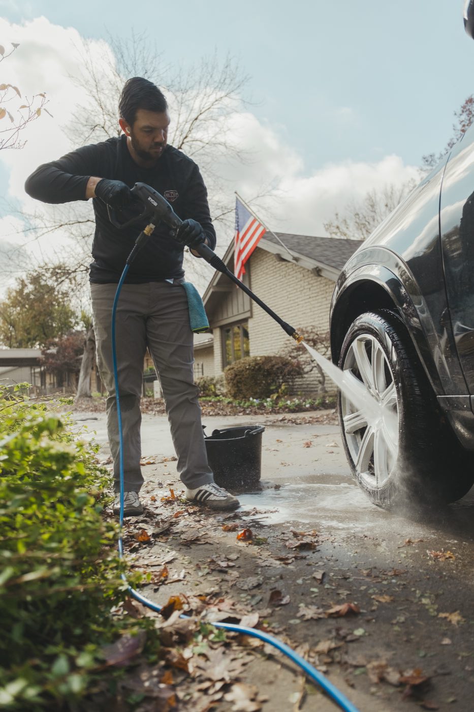 Pressure washing a wheel and tire during a mobile car detail in Tulsa, Oklahoma